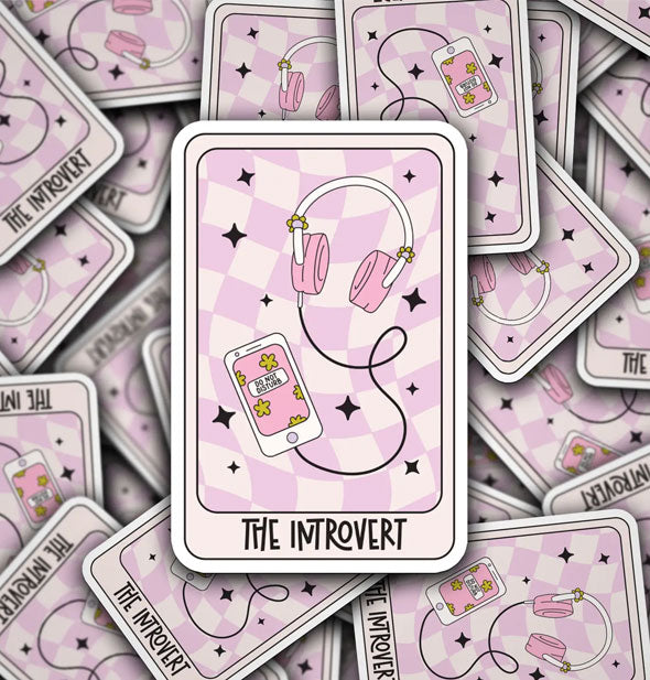 Rectangular stickers featuring tarot-style artwork of headphones and smartphone on a pink checkered background accented by black stars with the caption, "The Introvert"