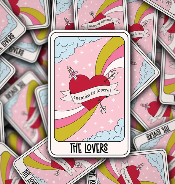 Rectangular stickers featuring illustration of a sword- and arrow-pierced red heart surrounded by radiant stripes, clouds, pink sky, and small white starts say, "The Lovers" in a tarot-style format
