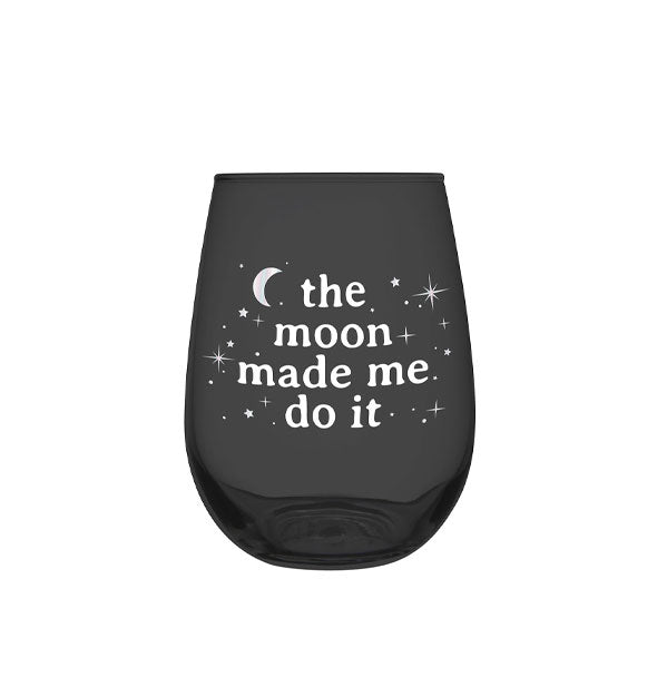 Stemless black wine glass says, "The moon made me do it" in white lettering surrounded by stars and a crescent moon
