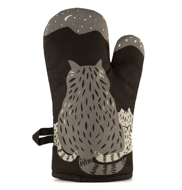 Black oven mitt features the backs of a family of raccoons below a starry night sky and mountain range in a grayscale color palette