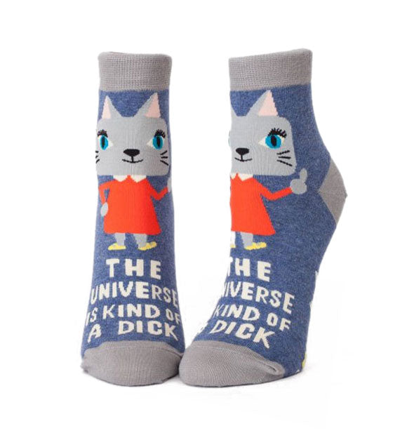 Pair of blue and gray socks with illustration of a kitten wearing a red dress and gesturing a middle finger say, "The universe is kind of a dick"