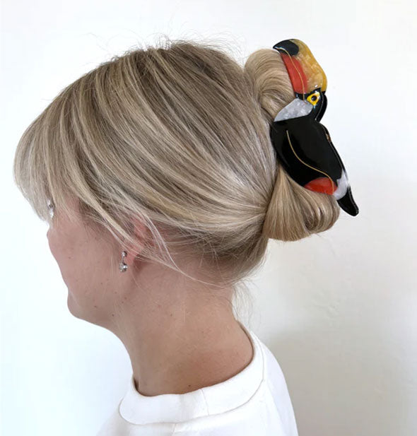 Model wears a toucan claw clip in a twist updo