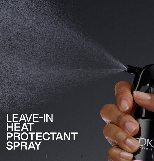 Model's hand dispenses a fine mist of Redken Acidic Color Gloss Heat Protection Treatment spray against a dark background and above the caption, "Leave-in heat protectant spray"