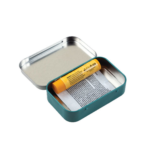 Open tin box with yellow chapstick tube and printed pill packet inside