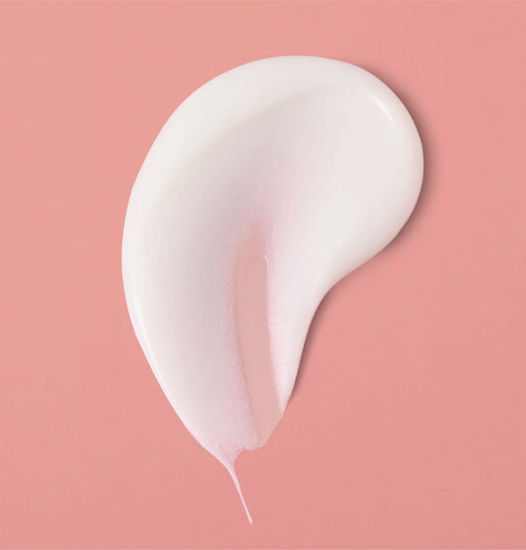 Daub of white, creamy Verb Volume Conditioner on a pink surface