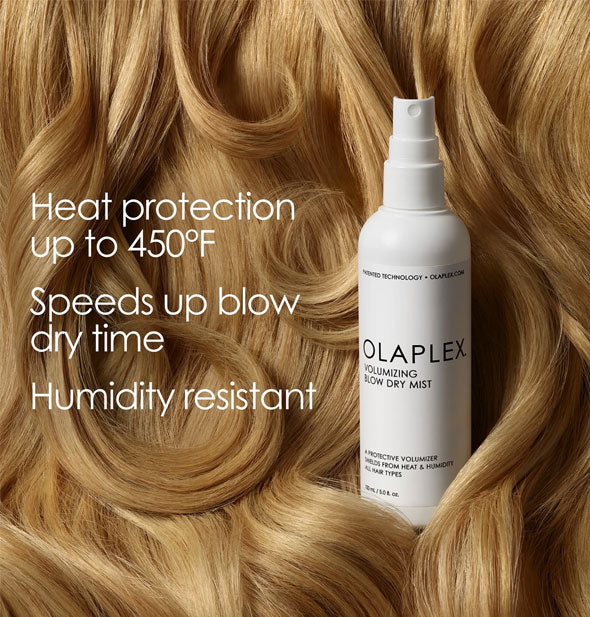 Bottle of Olaplex Volumizing Blow Dry Mist surrounded by thick locks of blonde hair says, "Heat protection up to 450°; Speeds up blow dry time; Humidity resistant"