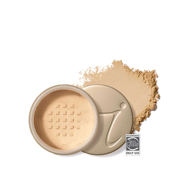 Opened round Jane Iredale loose powder compact with stamped gold lid and product application behind it in shade Warm Sienna
