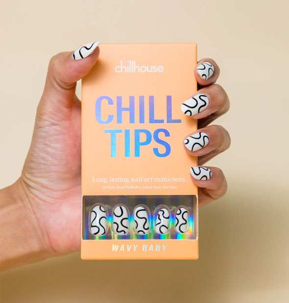 Model's hand with black and white squiggle pattern nails holds a Chillhouse Chill Tips Wavy Baby box with matching nails visible through packaging window