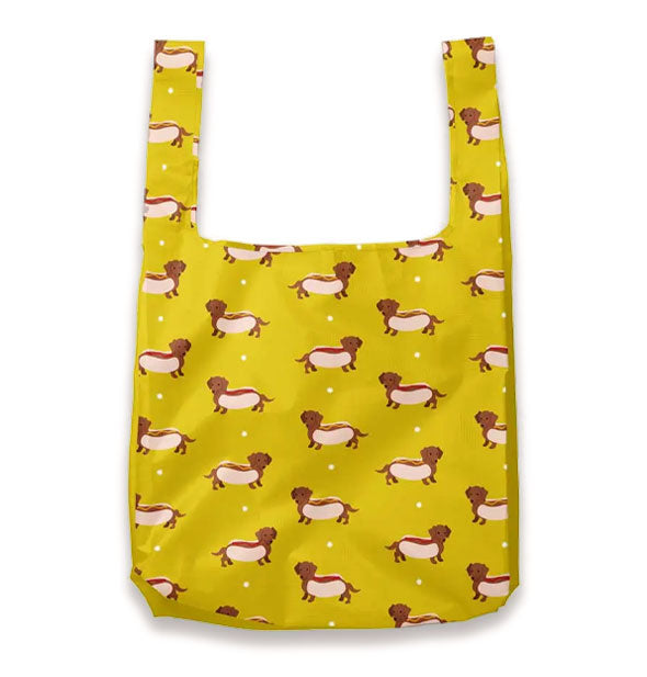 Mustard yellow tote bag features print of brown Dachshunds in hot dog buns accented by small white polka dots