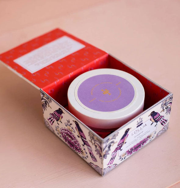 Opened Lollia Imagine Body Butter box with red interior reveals the lid of a jar inside with round purple label