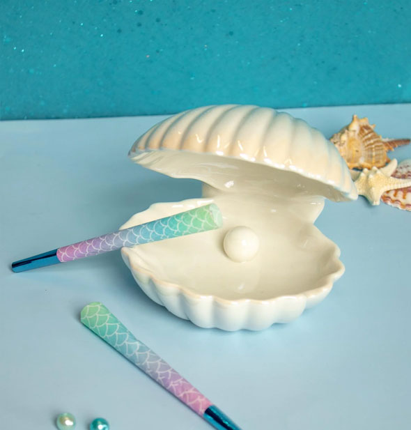 Iridescent white ceramic clamshell ashtray with rolled cigarette props