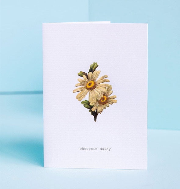 White greeting card with illustration of yellow daisies says, "Whoopsie daisy" at the bottom