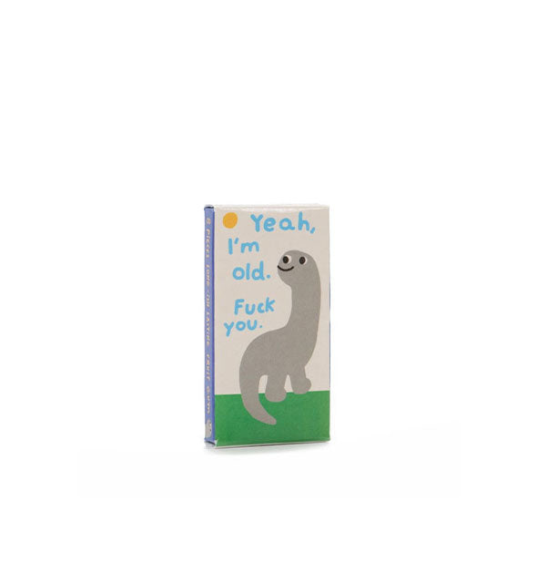 Flat rectangular box with rudimentary illustration of a gray dinosaur on green grass with a yellow sun in the sky says, "Yeah, I'm old. Fuck you" in blue lettering
