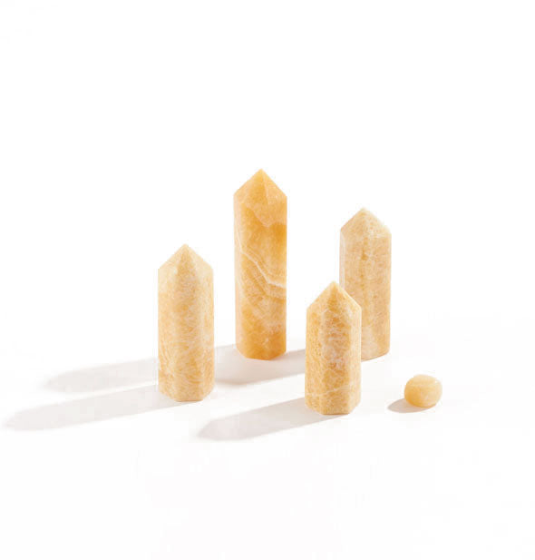 Collection of five yellow jade stones, four of which are tall with points and feature white and yellow swirl patterning throughout