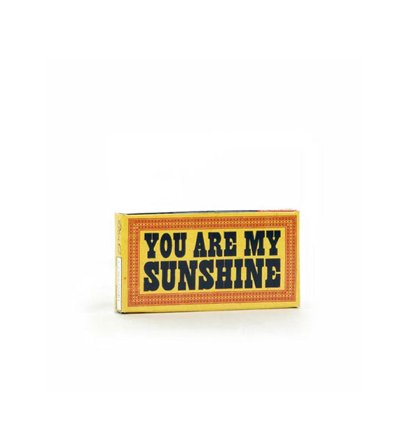 Rectangular yellow gum pack with orange border says, "You are my sunshine" in large black lettering