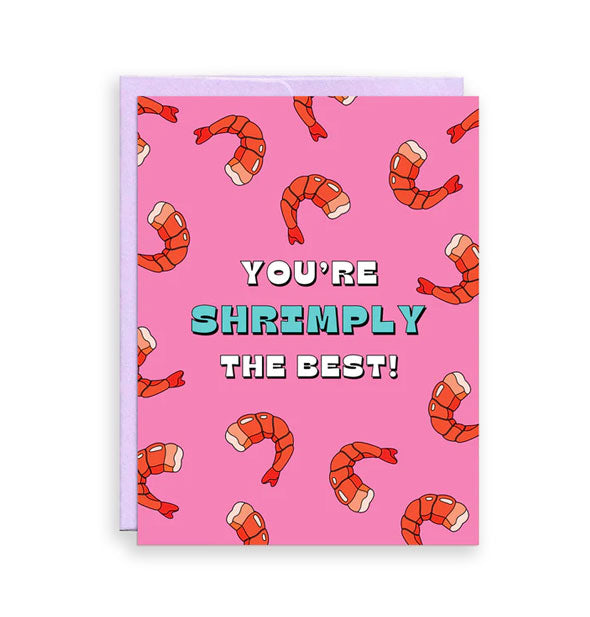 Pink greeting card backed by a purple envelope features illustrated print of orange shrimp around the message, "You're shrimply the best!" in white and teal lettering