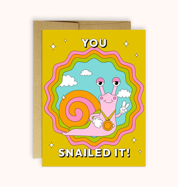 Mustard yellow greeting card with central design of a pink snail with pink and orange shell and a medal around its neck flashing a peace sign says, "You snailed it!"