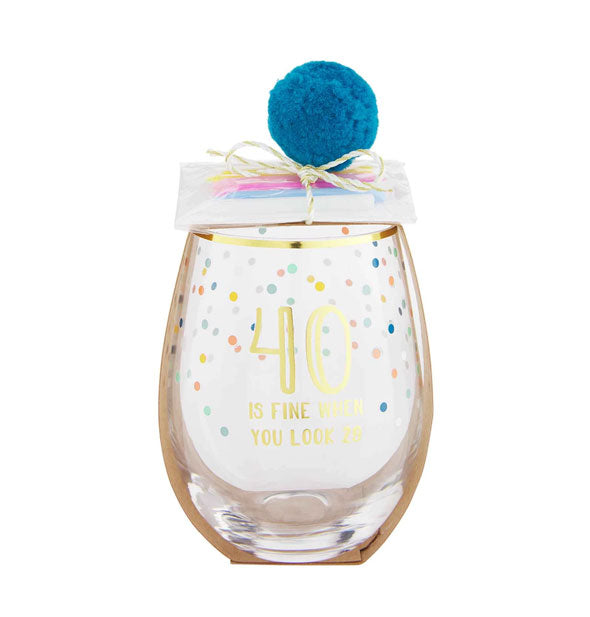 Stemless wine glass with gold rim, colorful confetti design, and blue pom pom with birthday candle pack attached says, "40 Is Fine When You Look 29" in gold foil lettering