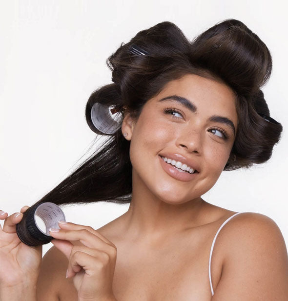 Smiling model wears rollers in her hair