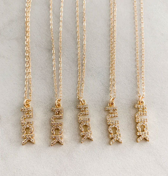 Five gold necklaces with rhinestone "FUCK" pendants