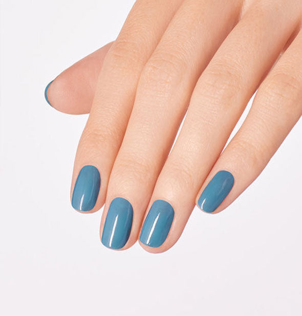 Model's hand wears a blue shade of nail polish