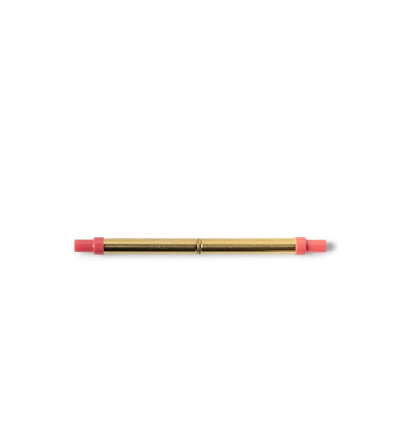 Collapsed gold-toned stainless steel straw with magenta plastic tips