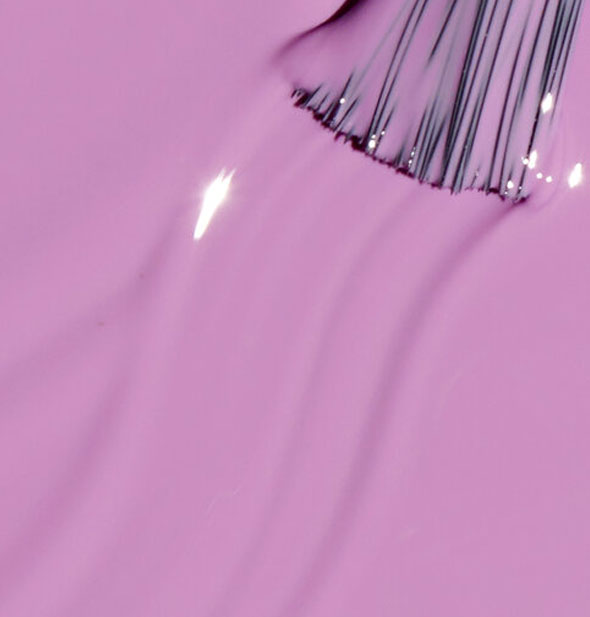 Pinkish-purple nail polish with brush tip swiped through it
