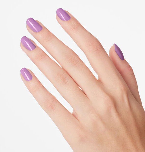 Model's hand wears a light purple shade of nail polish