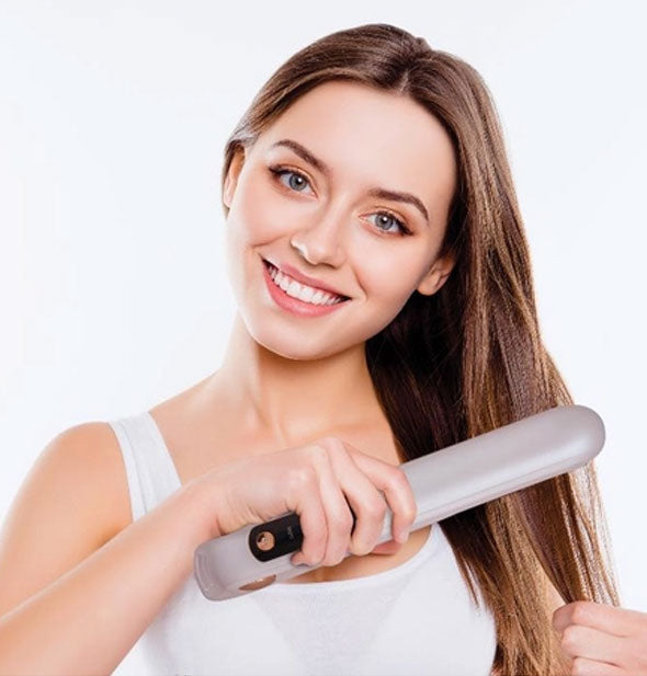 Model uses a hair straightening iron to style hair
