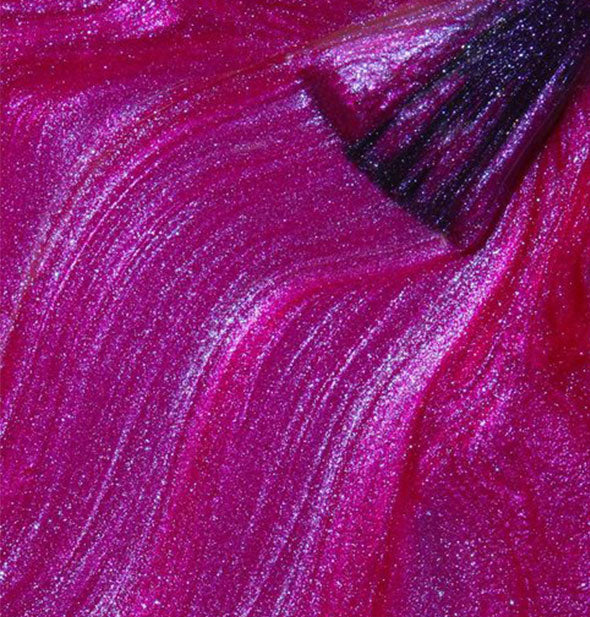 Shimmery, iridescent pink-purple nail polish with brush tip streaked through it