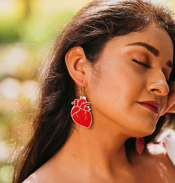 Model wears a red anatomical heart hoop earring
