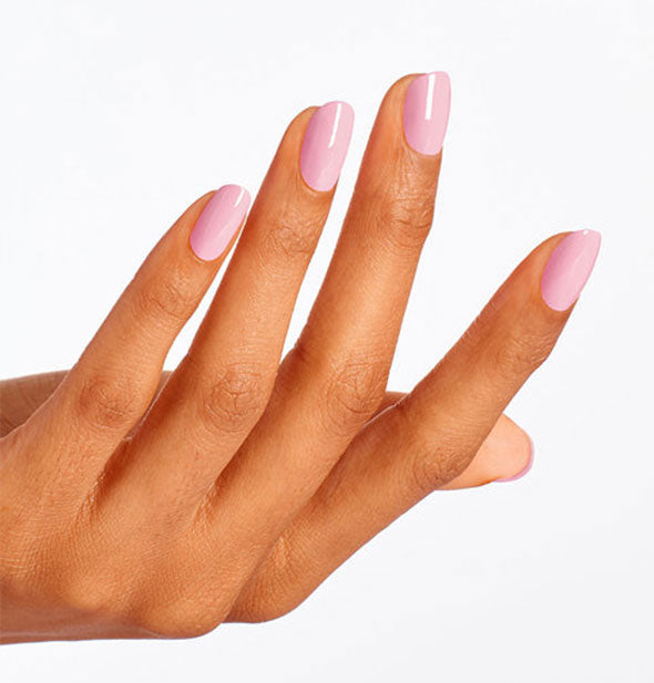 Model's hand wears a dusty rose shade of nail polish