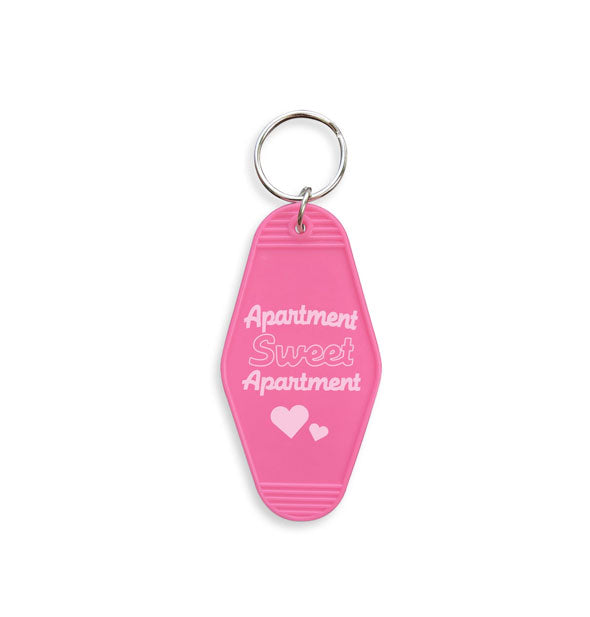 Pink motel-style keychain with silver ring says, "Apartment Sweet Apartment" in white lettering with heart graphics