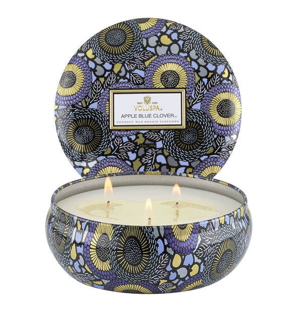 Round candle tin with purple and gold Japonica design on body and lid, set behind