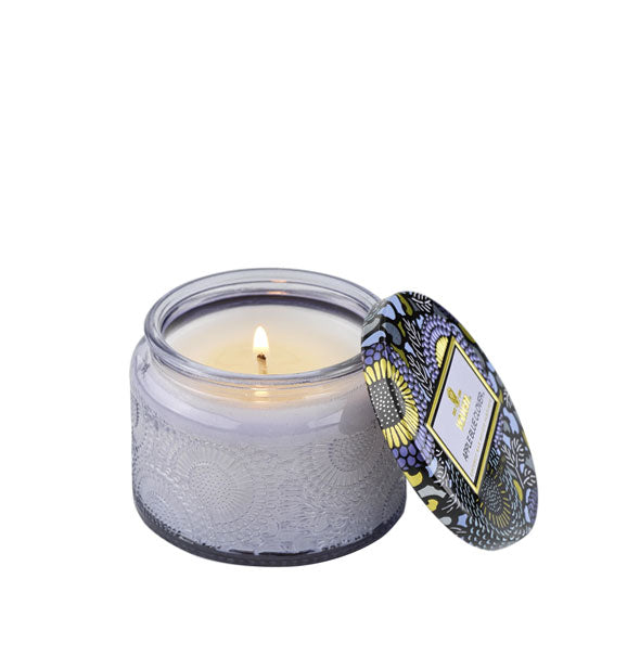 Embossed periwinkle candle glass with matching decorative tin lid to the side