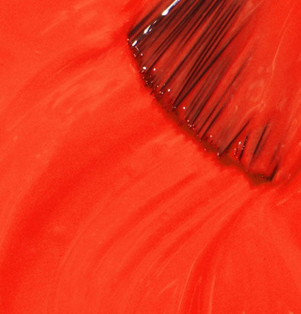 Vibrant red nail polish with brush tip drawn through