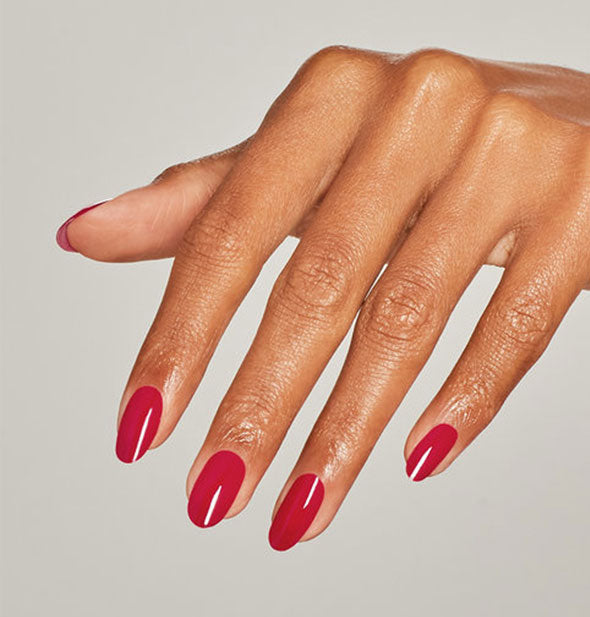 Model's hand wearing a red shade of nail polish