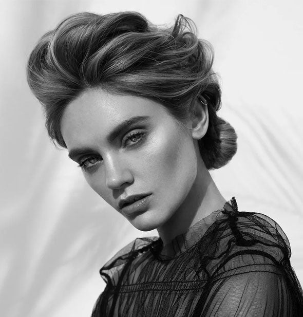 Model wears a volumized, swept-up hairstyle