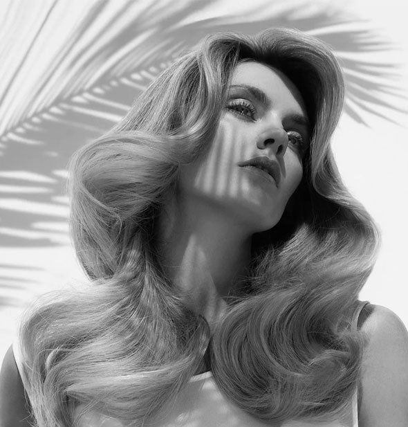 Model wears long hair styled with loose, cascading waves