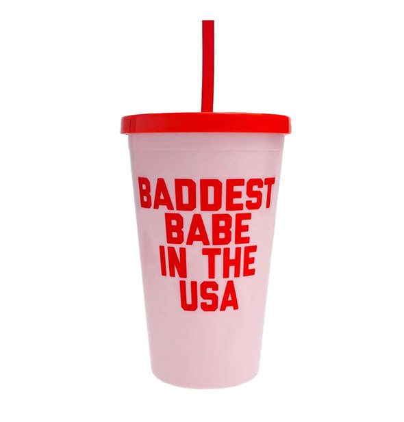 Light pink drink tumbler with red lid, straw, and lettering that says, "Baddest babe in the USA"