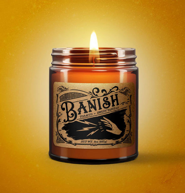 Lit Banish candle on yellow backdrop