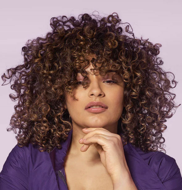Model with very curly hair demonstrates results of styling with Bumble and bumble Curl Defining Cream