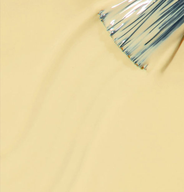 Soft yellow nail polish with brush tip streaked through it