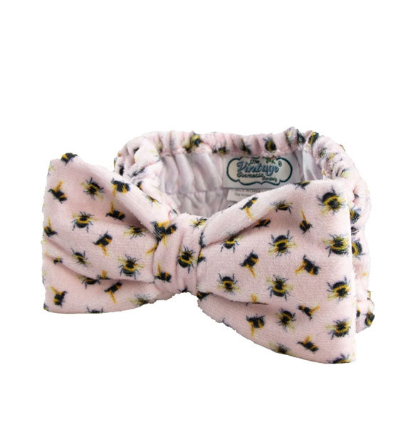 Wide ruched plush pink headband with bumblebee print and large bow detail
