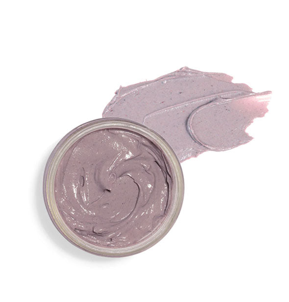 Top view of an opened pot of purple face mask with product sample application next to it