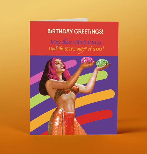 Greeting card with image of woman holding a colorful gemstone in each hand says, "Birthday greetings! May these crystals heal the shit out of you!"