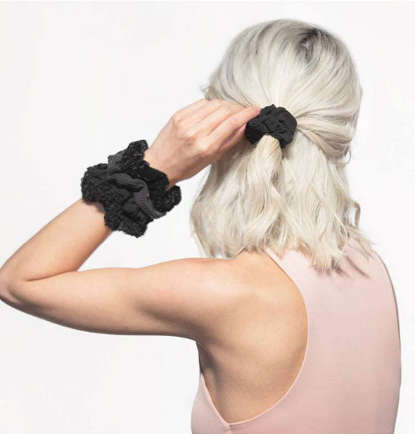 Model poses with scrunchies black shades in ponytail and on wrist