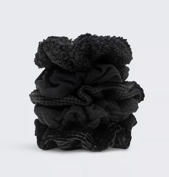 Set of five black hair scrunchies with different textured fabrics