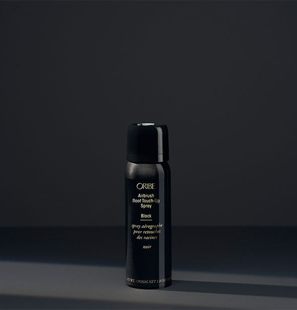 Small can of Oribe Airbrush Root Touch-Up Spray in the shade Black on a dark background