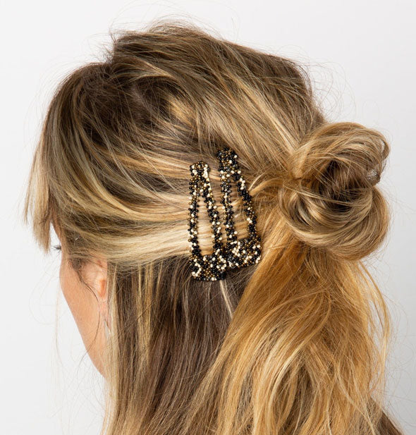 Model wears two beaded hair clips in a partial updo